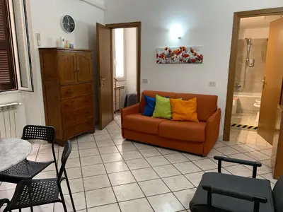 a living room with an orange couch with colorful pillows at Casa Adry in Rome