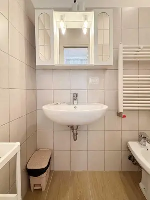 a white bathroom with a sink and a mirror at Piramide Suites 2 Bedrooms & 2 Bathrooms in Rome