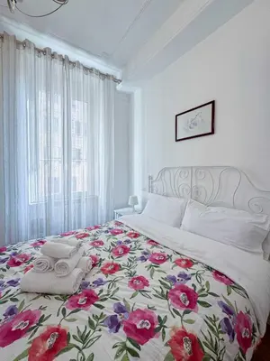a bedroom with a large bed with a floral bedspread at Piramide Suites 2 Bedrooms & 2 Bathrooms in Rome