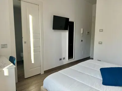 a bedroom with a white bed and a flat screen tv at Pope's bridge in Rome