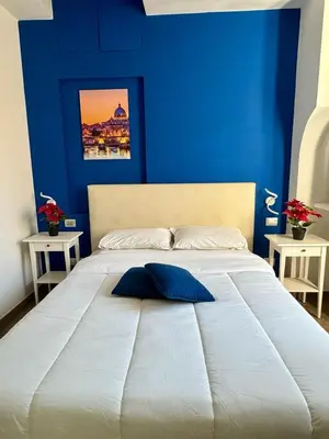 a blue bedroom with a large bed with a blue wall at Pope's bridge in Rome