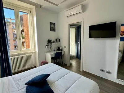 a bedroom with a bed and a television on a wall at Pope's bridge in Rome