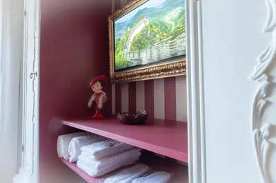 a shelf in a bathroom with towels and a painting at Olimpia House - Gianicolense in Rome