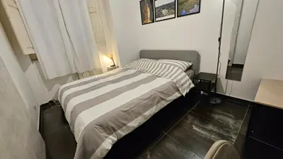 a small bedroom with a bed with a striped blanket at DidiHouse in Rome