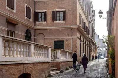 a group of people walking down a street next to a building at Emperor's View in Colosseum in Rome
