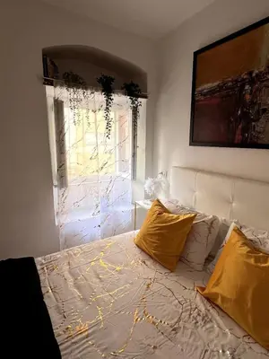 a bedroom with a bed with yellow pillows and a window at Shalimar Navona in Rome