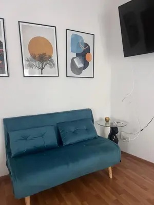 a blue couch in a living room with pictures on the wall at Shalimar Navona in Rome