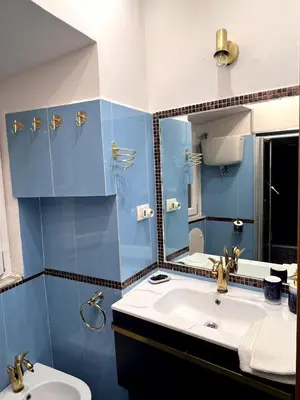 a blue bathroom with a sink and a mirror at Shalimar Navona in Rome