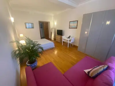 a living room with a pink couch and a bedroom at La Pianista sull'oceano in Rome