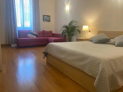 a bedroom with a large bed and a couch at La Pianista sull'oceano in Rome