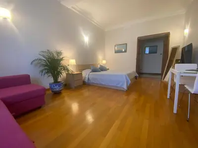 a bedroom with a bed and a couch and a table at La Pianista sull'oceano in Rome