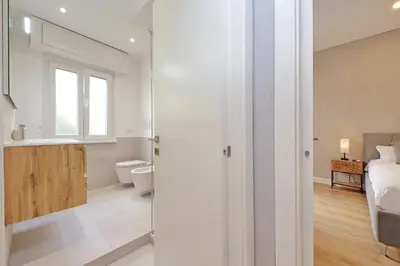 a white bathroom with a toilet and a sink at A casa in Rome