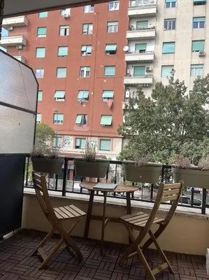 a balcony with a table and chairs and a building at A casa in Rome