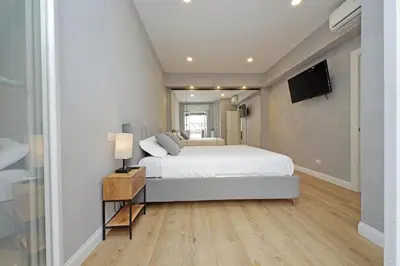 a bedroom with a white bed and a flat screen tv at A casa in Rome