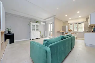 a living room with a blue couch and a kitchen at A casa in Rome