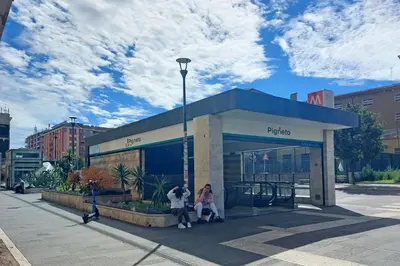 two people sitting in a bus stop in a city at A casa in Rome