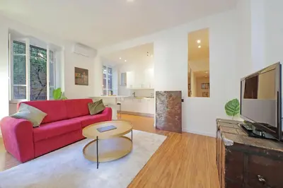 a living room with a red couch and a table at A casa, Aventino in Rome