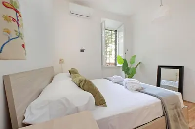 a bedroom with two beds with white sheets at A casa, Aventino in Rome