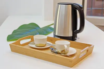 a wooden tray with two cups and a tea kettle at A casa, Aventino in Rome