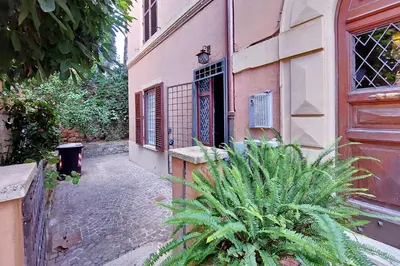 an alley with a door and a plant in front of a building at A casa, Aventino in Rome