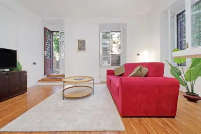 a living room with a red couch and a table at A casa, Aventino in Rome