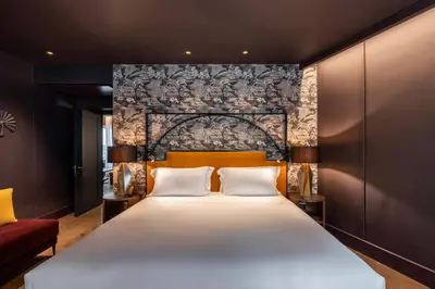 a bedroom with a large white bed with a brick wall at The Goethe Hotel - Small Luxury Hotels of the World in Rome
