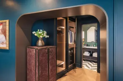 a closet with a vase of flowers on a wooden cabinet at The Goethe Hotel - Small Luxury Hotels of the World in Rome