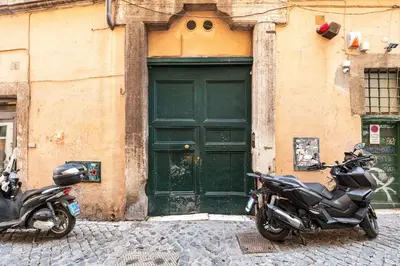 two motorcycles parked in front of a green door at Navona Charming Apartment by Romeloft in Rome