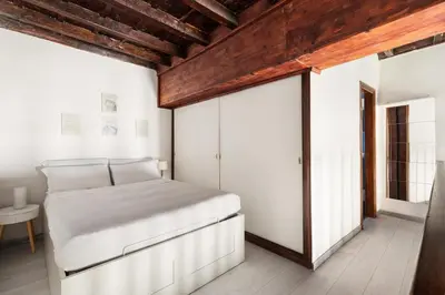 a bedroom with a white bed and a wooden ceiling at Navona Charming Apartment by Romeloft in Rome