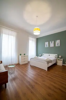 a bedroom with a large white bed and green walls at Flower Fields Home - Appartamento Campo dei Fiori in Rome
