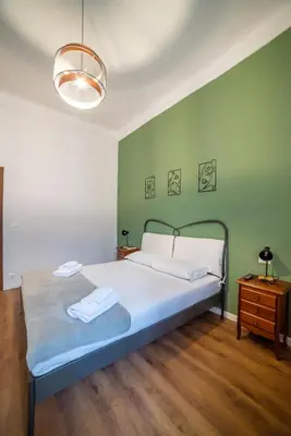 a bedroom with a bed and a green wall at Flower Fields Home - Appartamento Campo dei Fiori in Rome