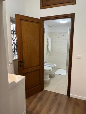 a bathroom with a toilet and a sink and a door at Flower Fields Home - Appartamento Campo dei Fiori in Rome