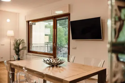 a dining room with a table and a large window at Dea Suites Two in Rome