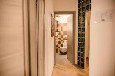 a corridor of a bathroom with a toilet and wine bottles at Dea Suites Two in Rome