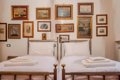 two beds in a room with pictures on the wall at Parcheggio Privato - Villa Liberty Roma Centro in Rome