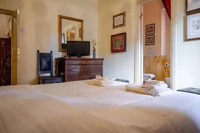 a bedroom with a white bed and a television at Parcheggio Privato - Villa Liberty Roma Centro in Rome