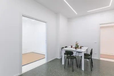 a white dining room with a white table and chairs at DOMUS LUX ANGELICA- Nearby Vatican in Rome