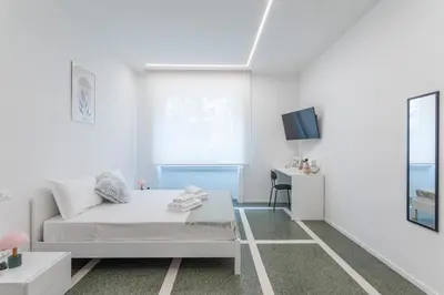 a white room with a bed and a desk at DOMUS LUX ANGELICA- Nearby Vatican in Rome