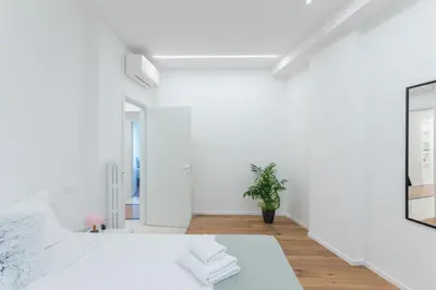a white room with a bed and a plant at DOMUS LUX ANGELICA- Nearby Vatican in Rome