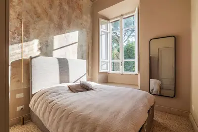 a bedroom with a large bed and a mirror at GuestHost - Central and Modern apartment in Rione Monti in Rome