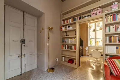 a bedroom with a door and book shelves with books at GuestHost - Central and Modern apartment in Rione Monti in Rome