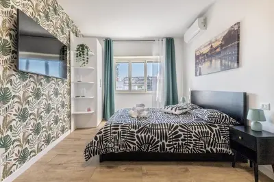 a bedroom with a black and white bed and a window at Green House Marconi in Rome