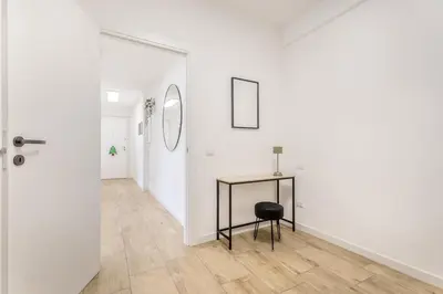a hallway with a table and a mirror at Green House Marconi in Rome