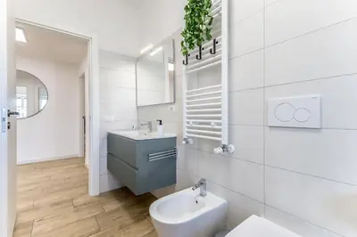 a white bathroom with a sink and a toilet at Green House Marconi in Rome
