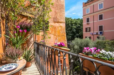 a balcony with a table and flowers on a building at Empire Loft in the shadow of Colosseum in Rome