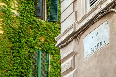 a sign on the side of a building with green ivy at Empire Loft in the shadow of Colosseum in Rome