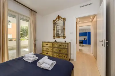 a bedroom with a blue bed and a mirror at Easylife - Vatican Terrace Apartment in Rome