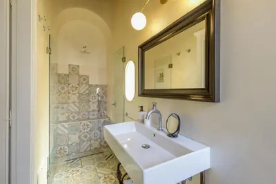 a bathroom with a sink and a mirror and a shower at Spanish Steps Boutique Apartment in Rome
