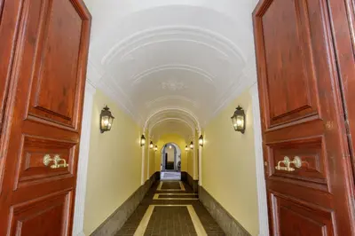 a hallway with wooden doors and yellow walls at Spanish Steps Boutique Apartment in Rome