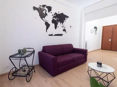 a living room with a purple couch and a world map on the wall at Alloggio Roma San Pietro da Silvia in Rome